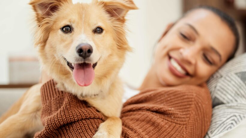 Hes all I need. Shot of a beautiful young woman relaxing on the couch with her dog at home.